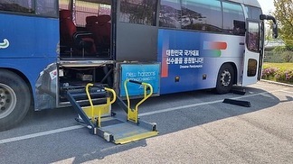 Un autocar accesible con su plataforma elevadora para sillas de ruedas desplegada.
