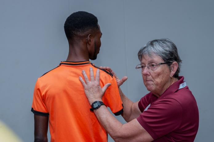 A coach demonstrates technique during Ahiagah’s training.