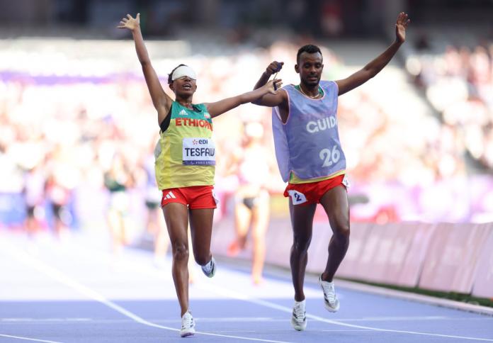 Yayesh Gate Tesfaw y su guía Kindu Sisay Girma celebran el oro etíope.