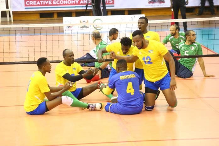 Jugadores ruandeses de voleibol sentado se reúnen en la cancha.