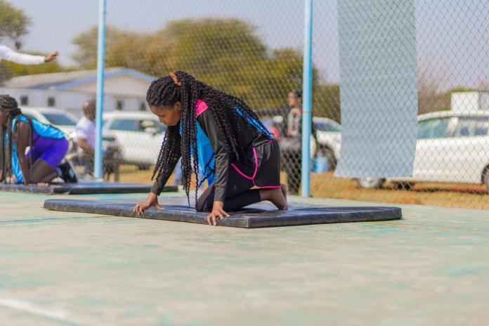 A child sits on a mat at the Botswana festival.