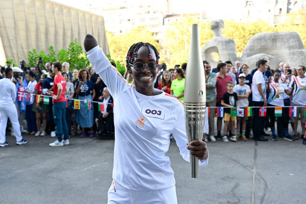 La ugandesa Husnah Kukundakwe sostiene la antorcha de París 2024