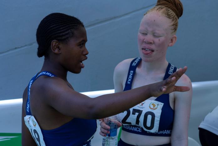 Kete talks with another sprinter beside the track.