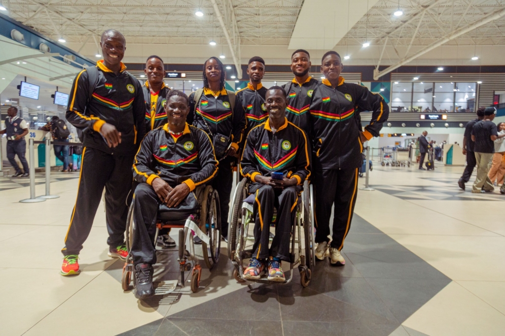 Ghana’s Para athletics delegation poses together in a terminal.