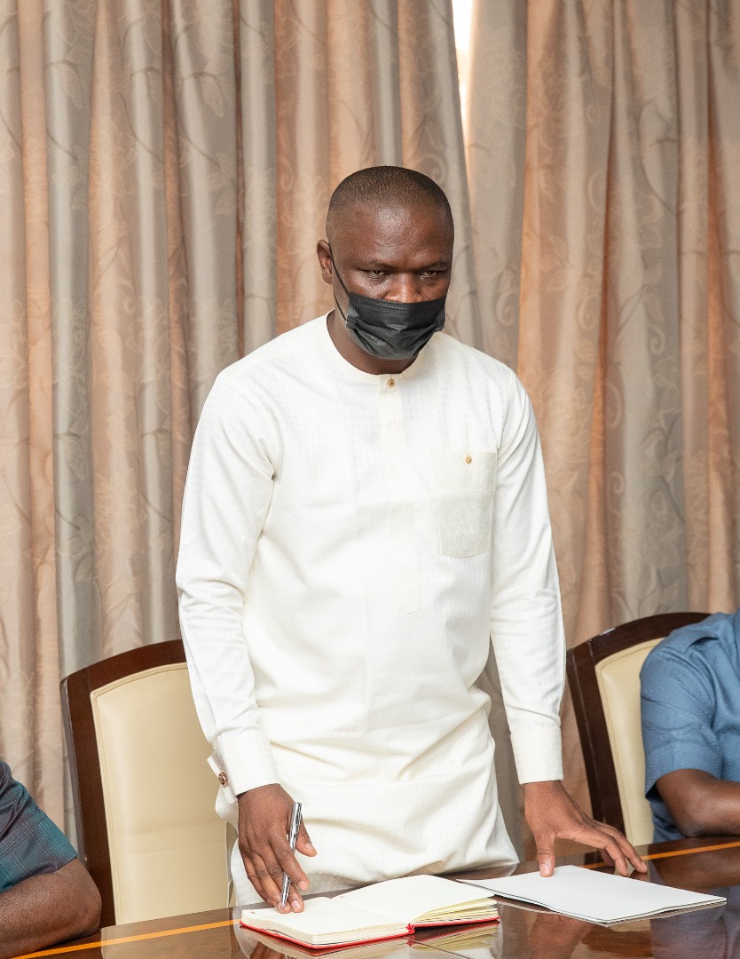Mustapha Ussif stands at the conference table during the presidential meeting.