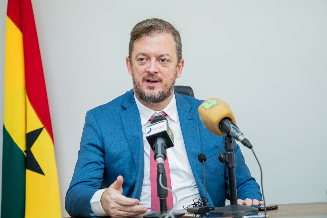 Andrew Parsons gestures while speaking into microphones during the Ghana visit.