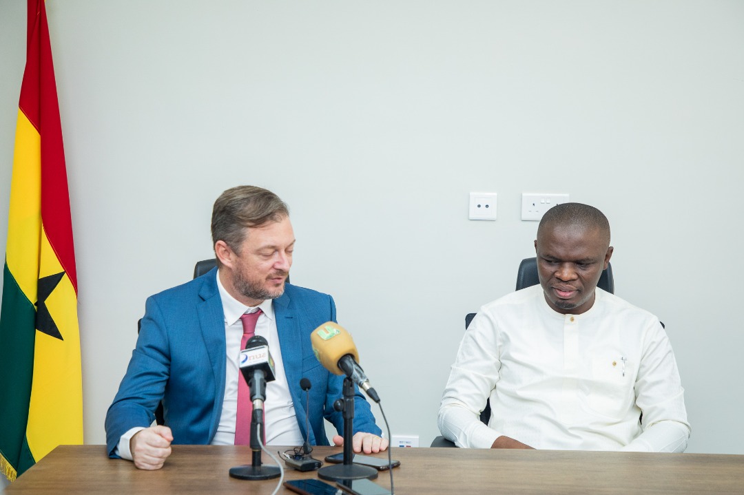 Andrew Parsons and Mustapha Ussif seated behind microphones beside the Ghana flag.