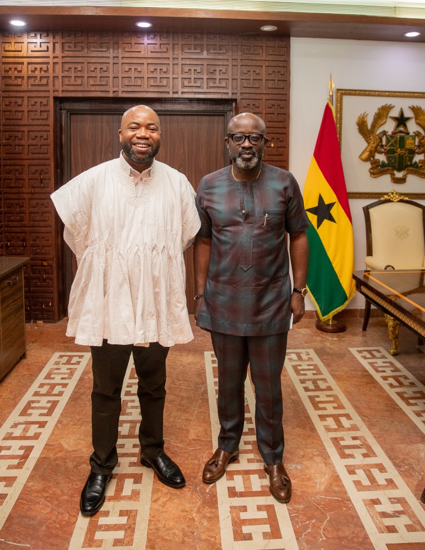 Two delegation members pose beside the Ghana flag in the supplied archive collection.
