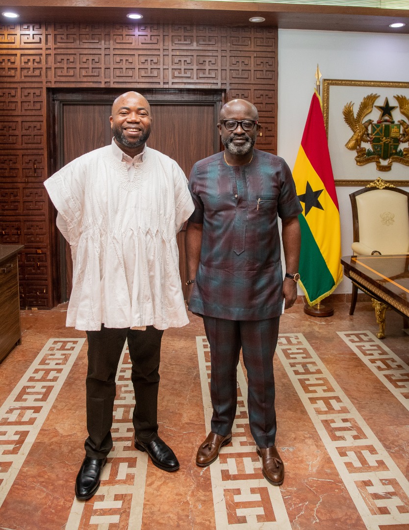 A second portrait of two delegation members beside the Ghana flag.