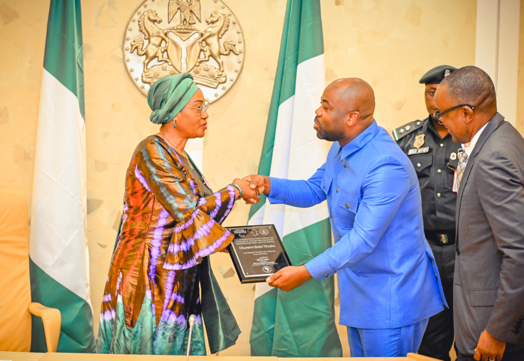 Samson Deen presents a commemorative plaque to Oluremi Tinubu during the Abuja meeting.